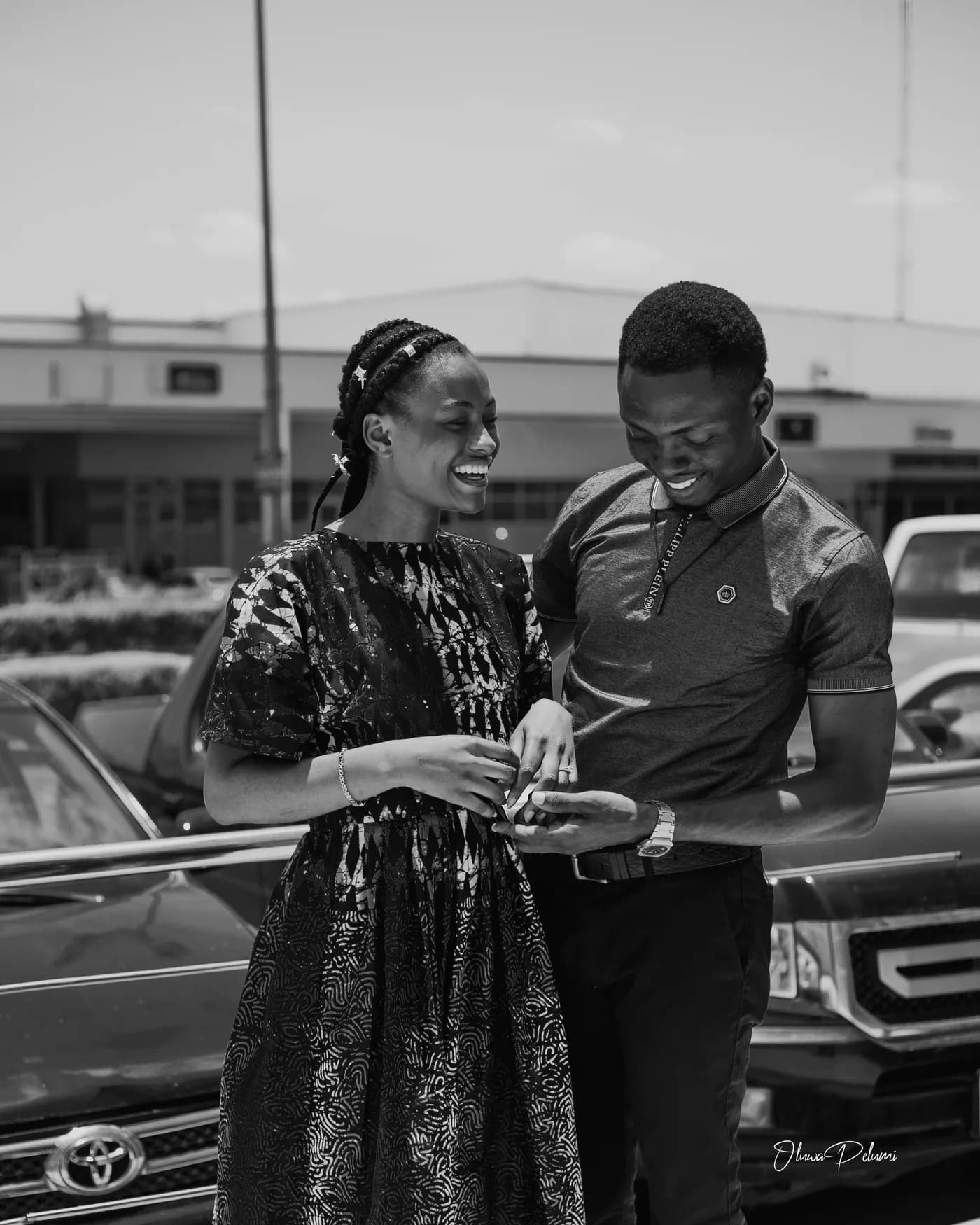 Asepe looking at her ring while Ajibola watches