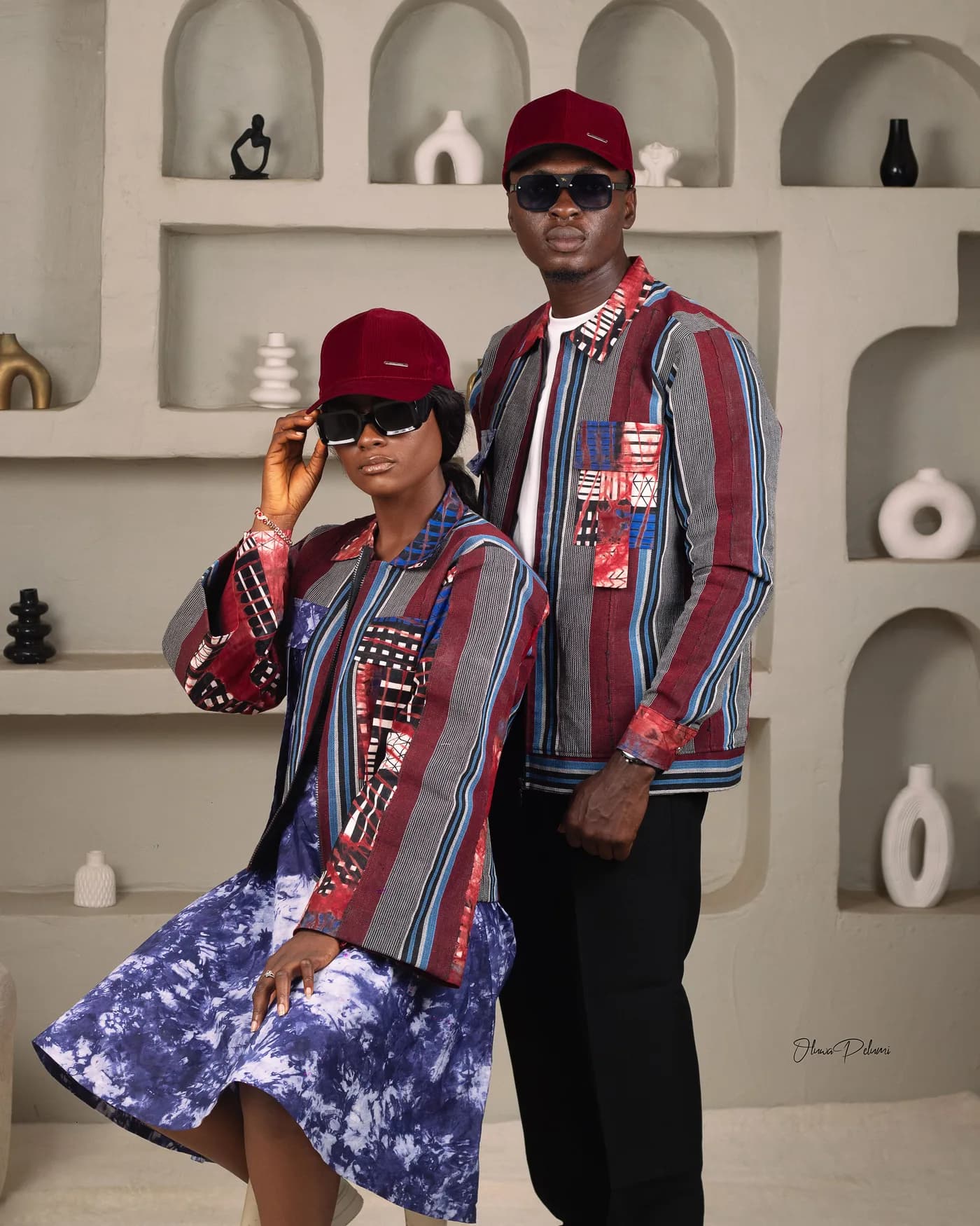 Asepe and Ajibola in matching outfits and caps, posing together